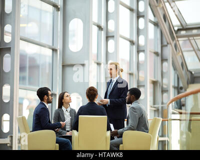 Successful analyst in formalwear speaking about his own investigation of situation on the market Stock Photo