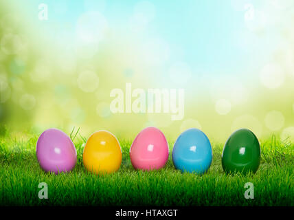 Colourful painted Easter Eggs on green grass and blurred garden background Stock Photo