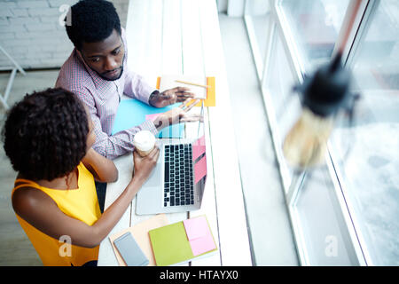 Two young analysts interacting in cafe Stock Photo
