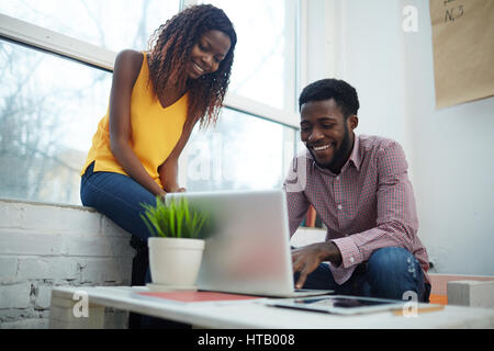 Smiling designers searching for data needed for their work Stock Photo