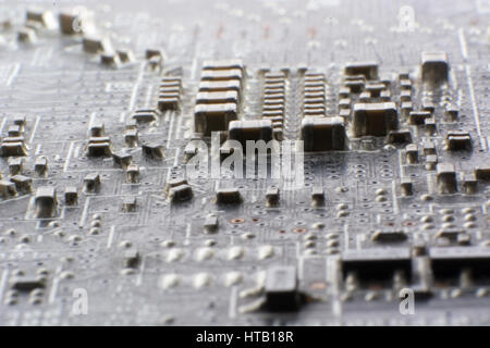 Surface-mount dusty smd components on used electronic circuit board close-up. Stock Photo
