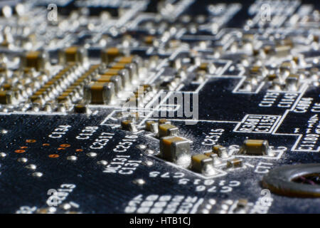 Surface-mount dusty smd components on used electronic circuit board close-up. Stock Photo