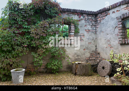 old wall in garden with vintage materials and plants and flowers Stock Photo