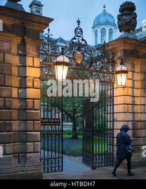 Students leaving Clare College, Cambridge at dusk, England, UK Stock Photo