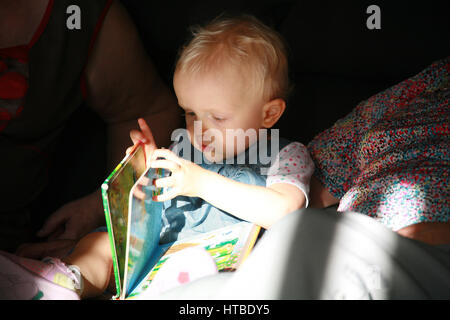 toddler girl reading a book Stock Photo