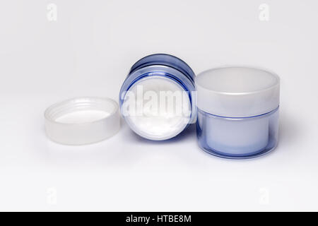 Two containers of moisturizing face cream on white background. Stock Photo