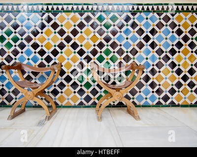 Two leather chairs in front of a colorful tiled wall. Stock Photo