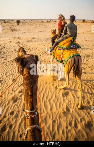 First person view riding a camel with another camel with two people riding it in front. Thar desert camel treking, Rajasthan, India. Stock Photo