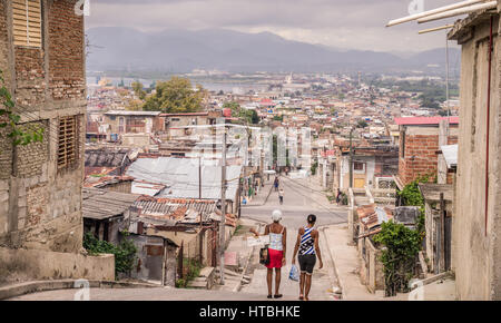 Santiago de Cuba, Cuba on January 4, 2016: Women walking down street in poor residential area Stock Photo