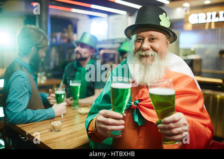 Senior man in hat holding two glasses of beer Stock Photo