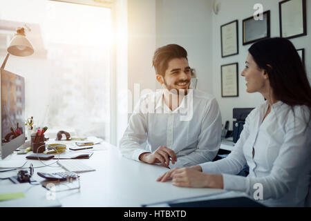 Happy collaborating business colleagues discussing future plans Stock Photo