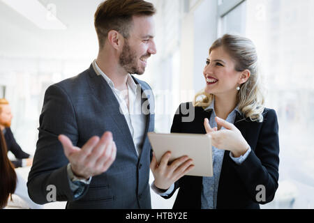 Smiling happy colleagues working at company office Stock Photo