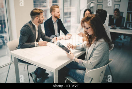Happy collaborating business colleagues discussing future plans Stock Photo