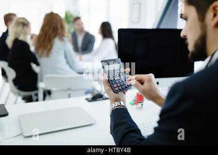Accountant checking statistics of company profit on calculator Stock Photo
