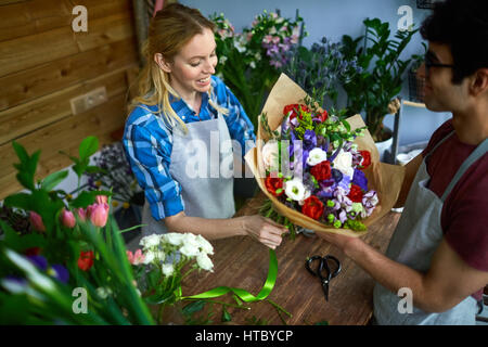 Young man and woman working in flower shop Stock Photo