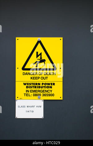 DANGER OF DEATH: A bright yellow warning sign warning of electrocution risk Stock Photo