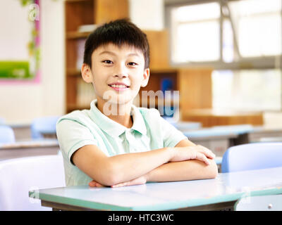 portrait of an eleven-year old asian elementary school student sitting in classroom. Stock Photo