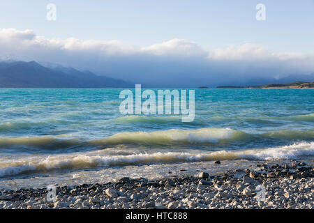 Twizel, Canterbury, New Zealand. View from shore across the choppy turquoise waters of Lake Pukaki, the Southern Alps obscured by cloud. Stock Photo