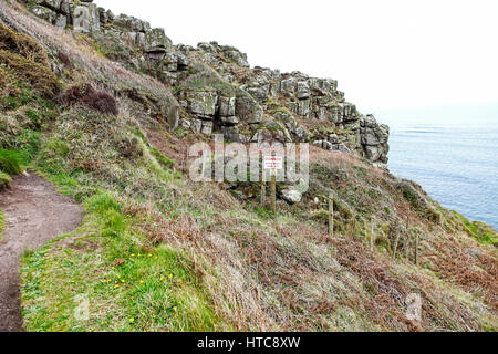 A sign saying keep out and warning of the dangers of a mine shaft on the South west Coast Path near to St. Just Cornwall England UK Stock Photo