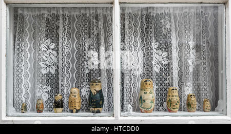 Old wooden Russian dolls displayed in a window. Stock Photo