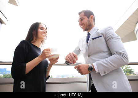 Business people having break on office terrace outdoor drinking coffee talking. Stock Photo