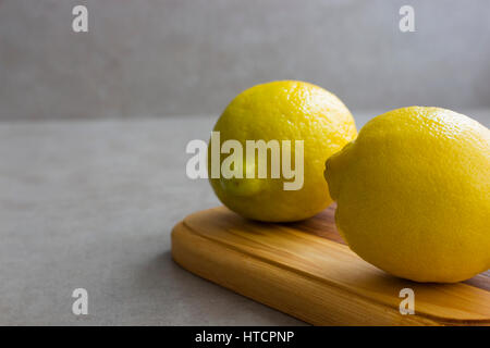 Two lemons on a wooden board. Stock Photo