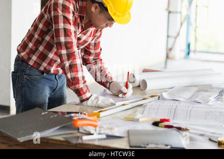 Architect, engineer, project manager or owner business working at office desk hands close-up, he is drawing on a building project with a pencil and a  Stock Photo