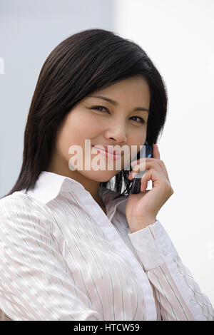 Businesswoman using a cellular telephone Stock Photo