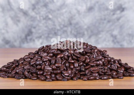 coffee beans on wood table with concrete wall background Stock Photo