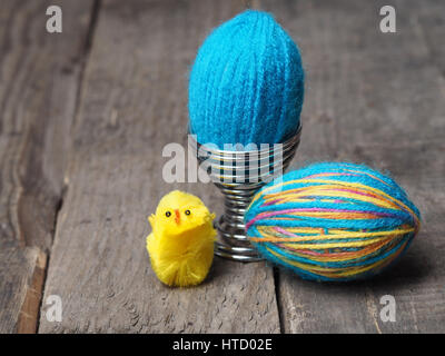 Two Easter eggs covered with wool yarn on a rutsic wooden table Stock Photo
