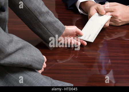 Businessman and businesswoman with blank cheque Stock Photo