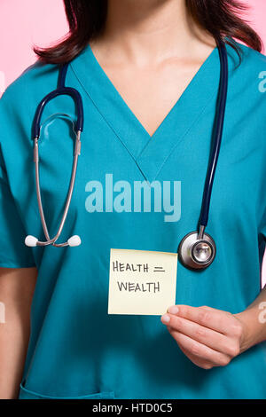 Female nurse holding an adhesive note Stock Photo