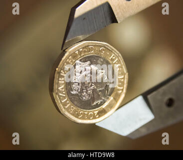 London, UK. 9th Mar, 2017. New £1 coins tested in the London Assay office ahead of their release 28th March, 2017. Pictured: One of the new 12 sided pound coins being measured by a Micrometer. This measures the diameter. It should be 23mm or within a certain tolerance of that. Credit: Guy Corbishley/Alamy Live News Stock Photo