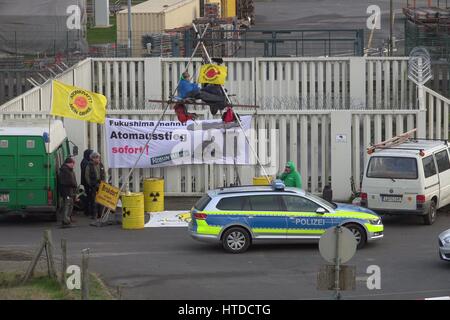 Brokdorf, Germany. 10th Mar, 2017. Activists from the environmental organization Robin Wood in front of the nuclear power station in Brokdorf, Germany, 10 March 2017. On a fence to the site is a banner that reads 'Fukushima mahnt: Atomausstieg sofort!' (lt. Fukushima warns: immediate nuclear phaseout!) Photo: Daniel Friederichs/Daniel Friederichs/dpa/Alamy Live News Stock Photo