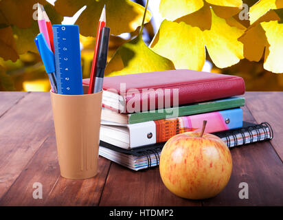 Stationery set and a stack of books on a wooden table Stock Photo