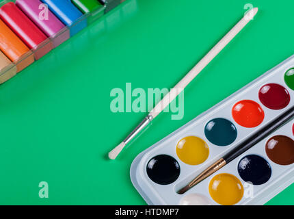 Watercolor paints and plasticine on a green background. For children's creativity Stock Photo