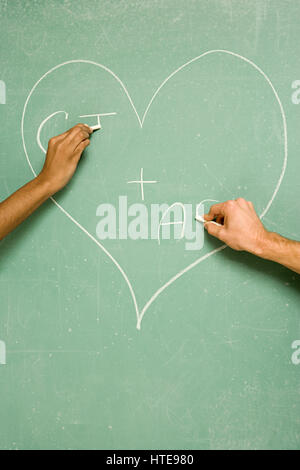 Two students drawing on blackboard Stock Photo