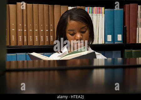 Female student reading in the library Stock Photo