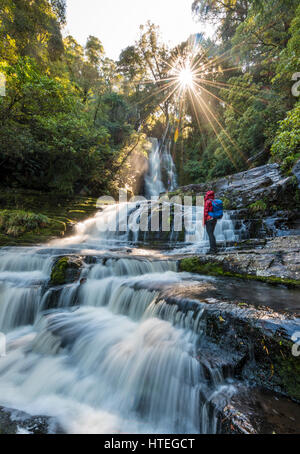 Hiker at McLean waterfall, Sun Star, The Catlins, Otago, Southland, New Zealand Stock Photo