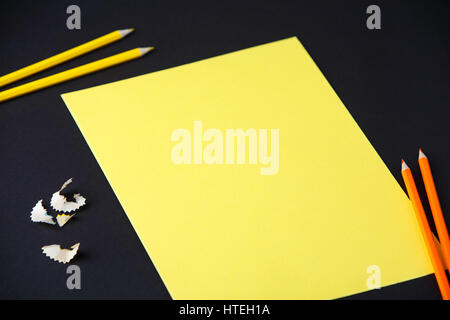 Pencil, shavings and yellow blank paper on dark background, business, design, school, office. School and education. Art and design. Stock Photo