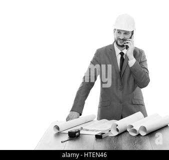 Always in touch. Mature male businessman engineer in a hardhat smiling talking on his phone looking away copyspace blueprints planning project archite Stock Photo