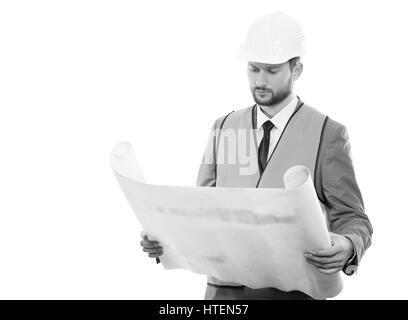 Final check. Black and white shot of a confident successful male constructionist in a hardhat and safety vest looking at the blueprints on white backg Stock Photo