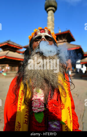KATHMANDU - OCT 10: Sadhu man smoking a cigarette in the Durbar square. On Oct 10, 2013 in Kathmandu, Nepal. Sadhus are holy men who are focusing on t Stock Photo