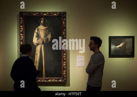 Visitors in front of the painting Saint Francis of Assisi according to the Vision of Pope Nicholas V (1640) by Spanish painter Francisco de Zurbaran displayed at the exhibition in the Kunsthalle Munchen in Munich, Bavaria, Germany. The exhibition devoted to the Spanish Golden Age runs till 26 March 2017. Stock Photo