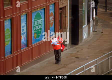 Royal Mail postman delivering letters street doorway buzzer Stock Photo