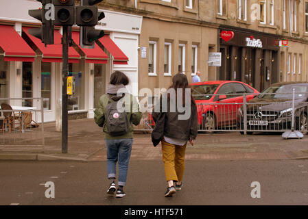 Glasgow City cityscape street scene crossing road at traffic lights Asian couple trendy fashionable young Stock Photo