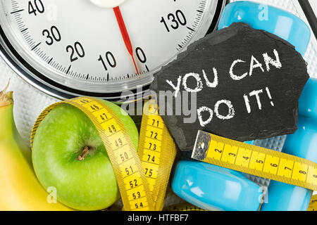 fitness diet motivation background concept apple banana measuring tape and slate on white bathroom scale Stock Photo