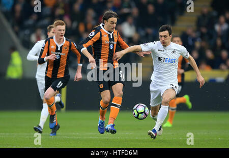 Hull City's Lazar Markovic (centre) and Swansea City's Jack Cork (right) battle for the ball during the Premier League match at the KCOM Stadium, Hull. Stock Photo