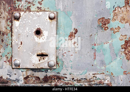 Weathered keyhole on an old rusty metal wall Stock Photo
