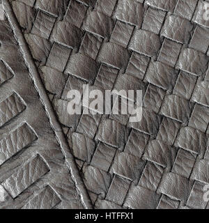Texture of genuine dark wicker leather close-up and details with stitches of male handbag. Stock Photo